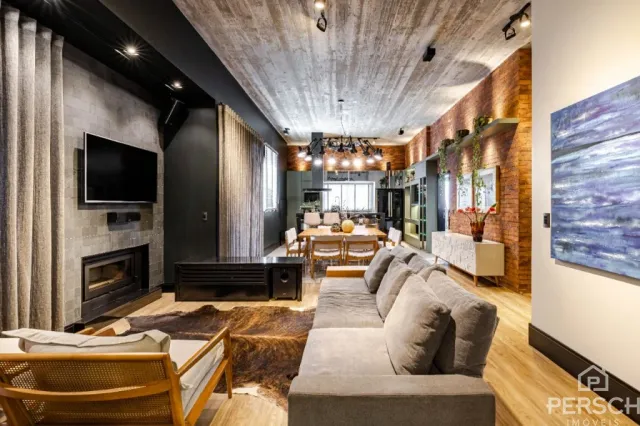 Sala de estar com sofá, televisão e lareira em ambiente moderno.