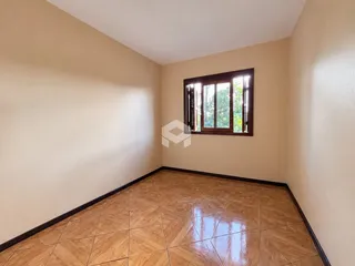 Vista interna de uma sala com piso de cerâmica e janela.