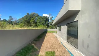 Fachada moderna de uma residência com paisagem verde ao fundo.