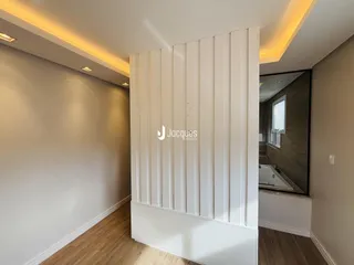 Hall com piso de madeira e parede branca em imóvel no Brasil.