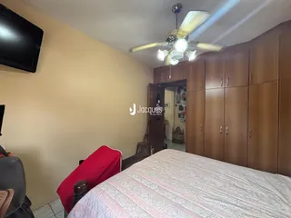 Quarto com armários de madeira e cama no interior de uma residência.