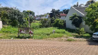 Vista externa de uma propriedade residencial com grama alta no primeiro plano.