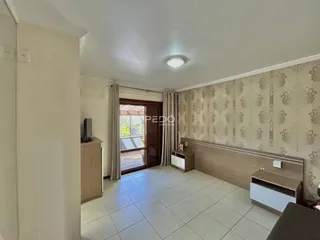 Ambiente interno de uma sala com piso de cerâmica e parede com papel de parede.