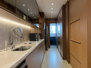 Cozinha moderna com bancada de mármore e armários em madeira.