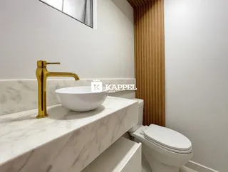 Banheiro com bancada de mármore e vaso sanitário branco.
