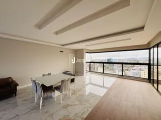 Sala de estar e jantar com grandes janelas que oferecem uma vista da cidade.