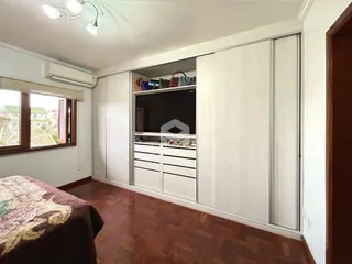Quarto com armário embutido e piso de madeira.