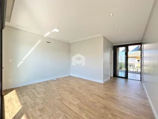 Ambiente interno amplo com piso de madeira clara.