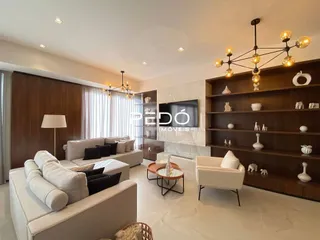 Sala de estar moderna com painéis de madeira e sofá claro.