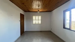Uma sala de estar com teto de madeira e piso de cerâmica.