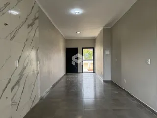 Corredor interno de uma residência com piso de cerâmica.