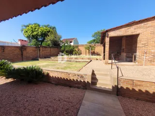 Vista externa de um muro de tijolos e área gramada de uma propriedade em Lajeado.
