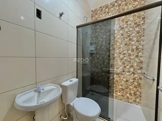 Foto de um banheiro com azulejos brancos e marrons.