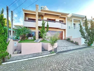 Fachada de uma casa em Lajeado, Brasil, com jardim frontal e entrada de garagem.
