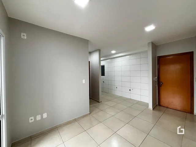 Corredor com piso de cerâmica claro e paredes brancas.