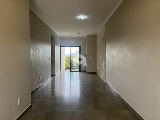 Corredor interno de uma residência com piso de cerâmica escura.
