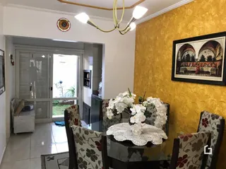 Sala de estar com parede amarela e porta de entrada.
