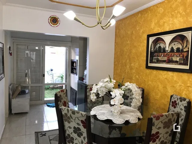 Sala de estar com parede amarela e porta de entrada.