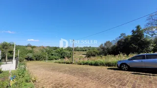 Vista externa de um terreno com vegetação e uma estrada no fundo.