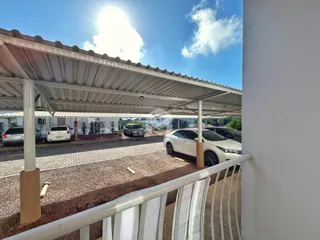 Vista externa de uma propriedade com uma estrutura de cobertura e grade de proteção.