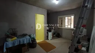 Interior de um cômodo com parede cinza e porta amarela.