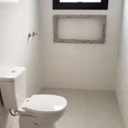 Foto de um banheiro com um vaso sanitário branco.