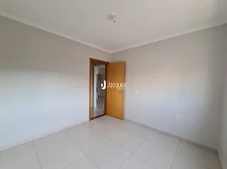 Interior de um cômodo com piso de cerâmica e porta de madeira.