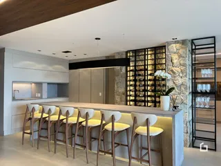 Vista de uma cozinha moderna com balcão e bancos em um imóvel no Brasil.