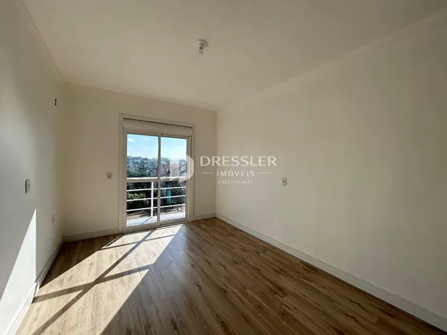 Sala de estar com piso de madeira e grande janela.