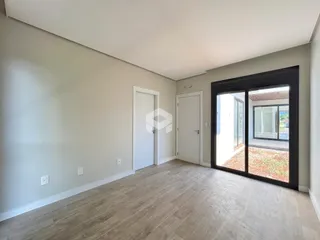 Vista interna de um ambiente com paredes cinzas e piso de madeira clara.