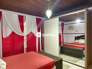 Um quarto com cama de casal e cortinas vermelhas e brancas.