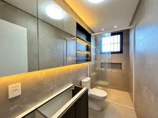 Banheiro com box de vidro e bancada de mármore.