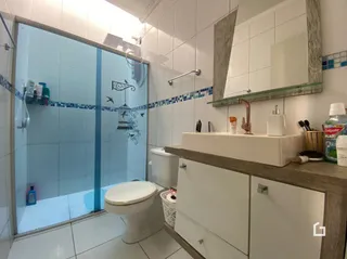 Foto de um banheiro com revestimento cerâmico nas paredes.