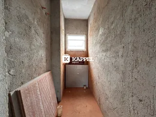 Foto de um corredor interno com paredes de concreto aparente.