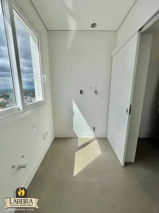 Vista interna de um corredor com janela grande em um imóvel em Lajeado.
