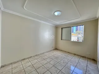 A sala apresenta piso de cerâmica clara e paredes brancas.