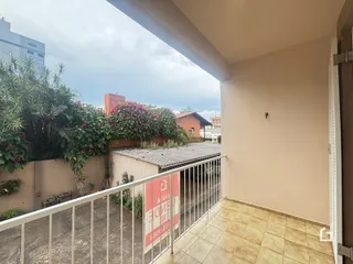 Vista da varanda com piso de cerâmica e grade de segurança.