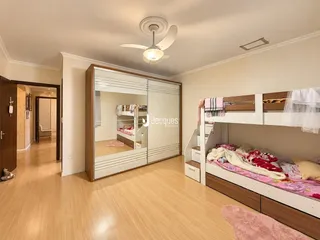 Quarto com armário e cama de solteiro em ambiente claro.