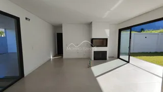 Ambiente interno amplo com paredes brancas e piso claro, com acesso a área externa.