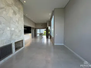 Vista ampla de um ambiente interno com piso claro e parede de pedra.