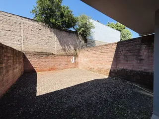 Vista externa das paredes de tijolo e do solo do imóvel.