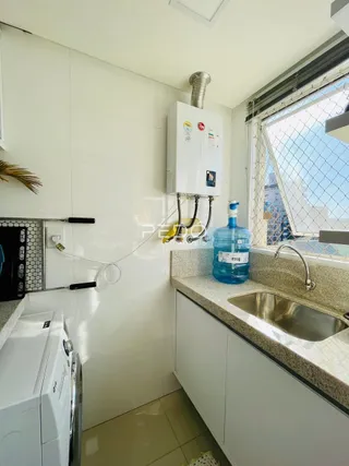 Foto de uma cozinha com armários brancos e bancada clara.