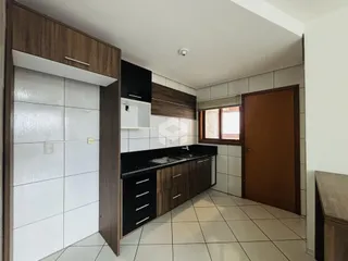 Cozinha com armários de madeira e piso cerâmico.