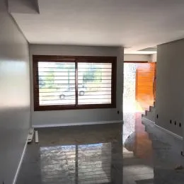 Corredor interno com janela e piso reflexivo.