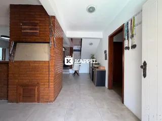 Hall de entrada com parede de tijolos aparentes e piso de cerâmica.