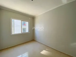 Ambiente interno de uma sala com piso claro e parede branca.