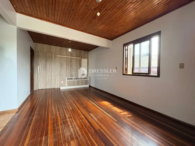 Sala de estar com piso de madeira e teto de madeira em um imóvel em Lajeado.