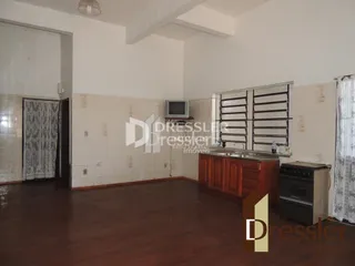 Ambiente interno com piso de madeira e paredes brancas.