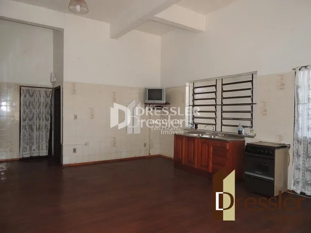 Ambiente interno com piso de madeira e paredes brancas.