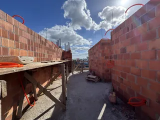 Vista externa de paredes de tijolo em construção em uma propriedade.